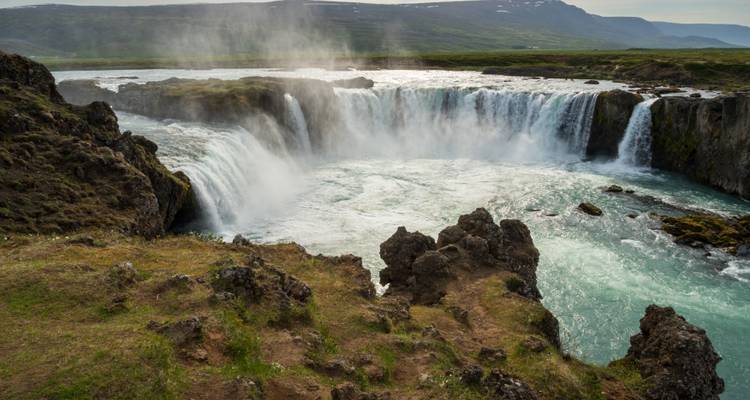 La cascade de Godafoss rugit majestueusement en se précipitant du haut des falaises dans un bassin fluvial turquoise.