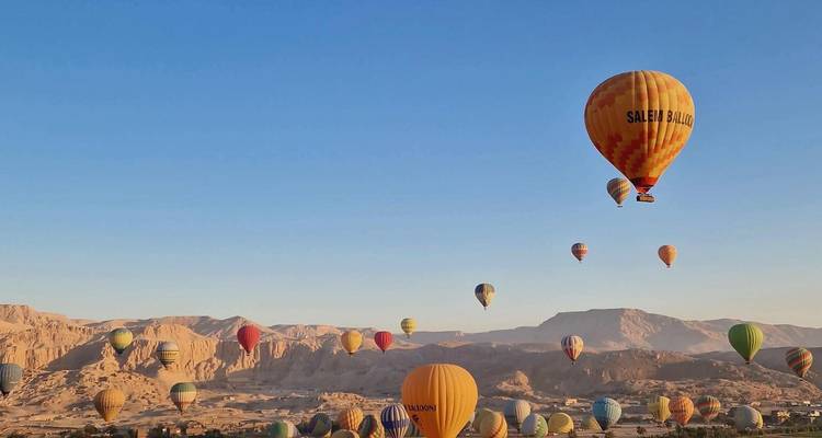 Dozens of colorful hot air balloons floating over the Nile Valley at dawn