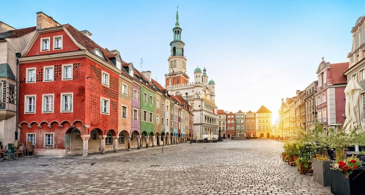 Les maisons en terrasses colorées et la tour de l'hôtel de ville historique entourant la Place du Marché Ancien de Poznan à l'aube