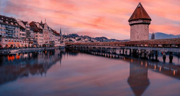 Vista de atardecer de ensueño del Puente de la Capilla de Lucerna y la torre del agua reflejándose en las aguas tranquilas del río