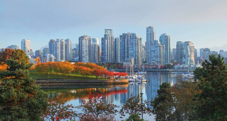 Autumn foliage and sailboats along Vancouver False Creek with high-rise skyline backdrop