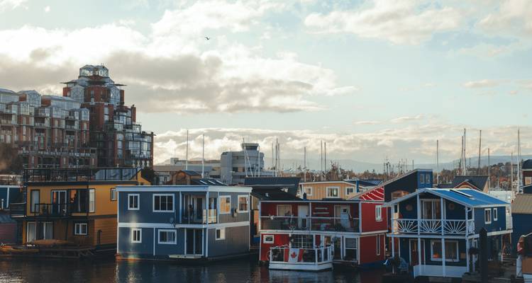 Colourful floating houses in a harbour with modern apartment blocks behind