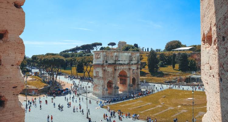 View of the Arch of Constantine and bustling plaza framed by ancient walls and green parkland