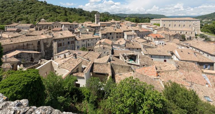 Vue depuis une terrasse sur les maisons en pierre densément construites d'une ville médiévale provençale.