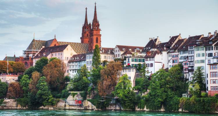 Baseler Skyline mit Münster-Türmen und farbenfrohen Häusern entlang des Rheins.