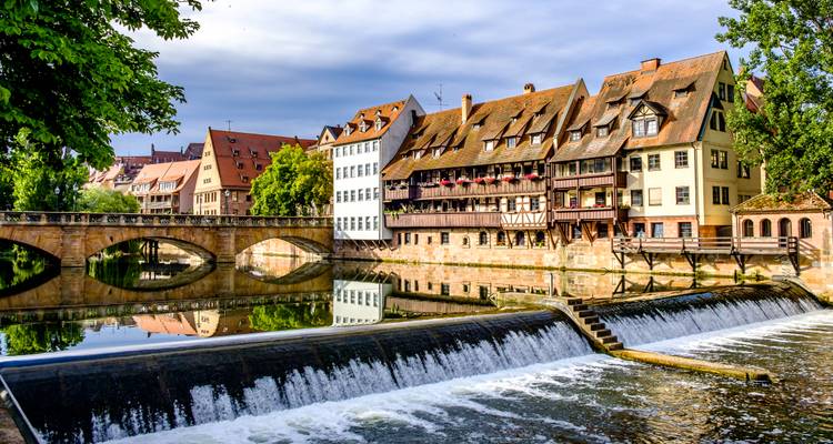 Pont de pierre, maisons médiévales et barrage en cascade se reflètent dans la tranquille rivière Pegnitz à Nuremberg