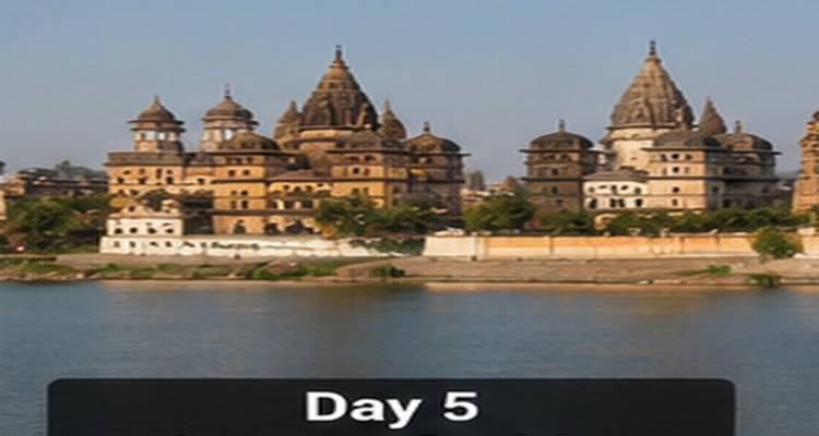 Historische Flussseiten-Kenotaph-Tempel von Orchha, die sich an einem sonnigen Tag hinter ruhigem Wasser erheben.