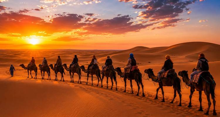 Caravane de chameaux en silhouette traversant les dunes de sable brillantes au coucher du soleil avec un ciel dramatique