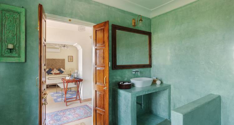 Répétez la salle de bains verte élégante avec des accents en bois et un grand miroir