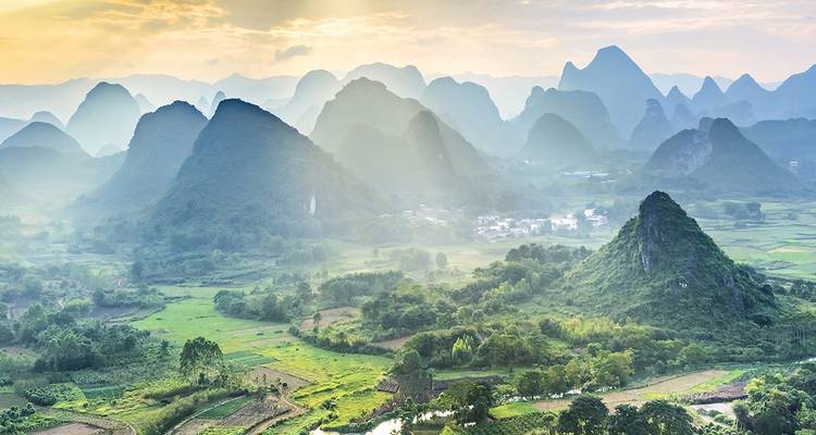 Lever de soleil brumeux sur des pics de karst spectaculaires et des vallées en damier près de Yangshuo.