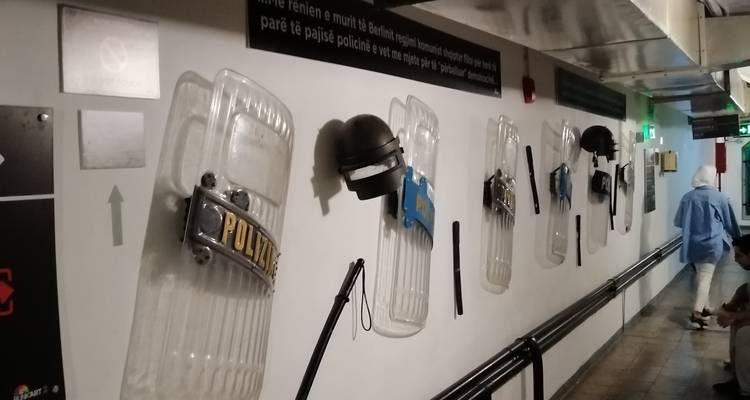 Unterirdischer Museumskorridor mit Polizeischutzschilde und Helme, die an der Wand ausgestellt sind