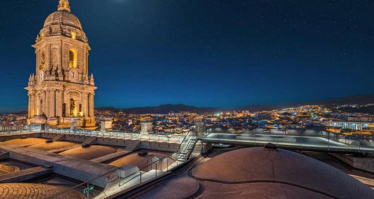 Le panorama nocturne du toit de la Cathédrale de Malaga offre une vue sur les lumières scintillantes de la ville sous un ciel étoilé.