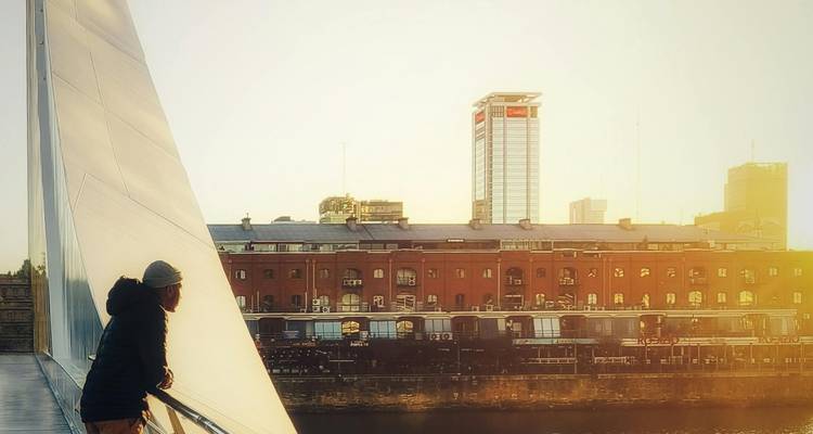 Voyageur appuyé contre le pont Puente de la Mujer au lever du soleil dans le quartier Puerto Madero de Buenos Aires.