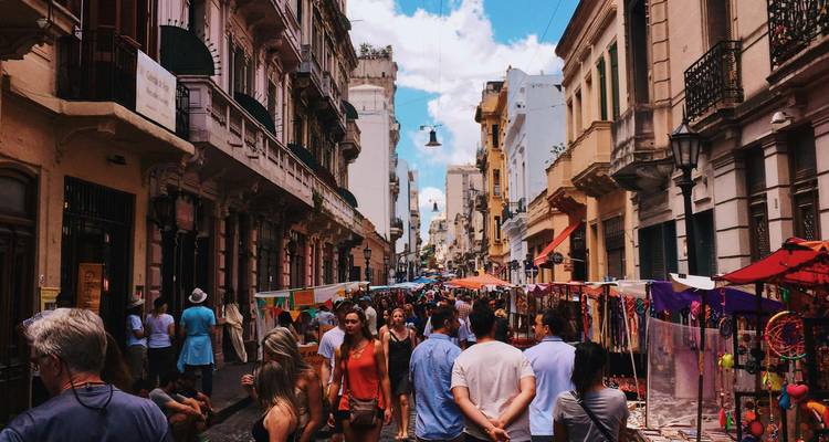Rue du marché en plein air animée à San Telmo avec des acheteurs et des étalages colorés.