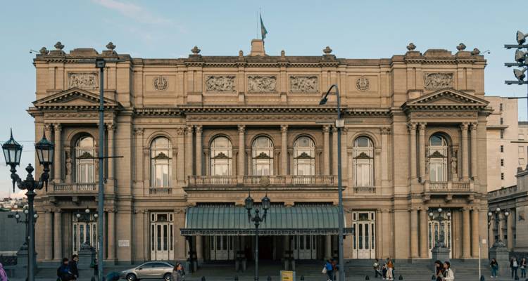 Façade grand néoclassique de l'opéra Teatro Colón avec des visiteurs à l'extérieur.