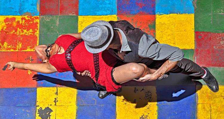 Bovenaanzicht van tangodansers op een veelkleurige tegelvloer met sterke schaduwwerking