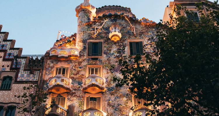 Façade colorée et ornementale de la Casa Batlló de Gaudí illuminée au crépuscule