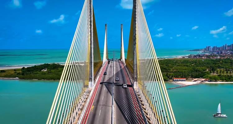 Pont à haubans enjambant des eaux turquoise avec la ligne d'horizon de la ville au loin