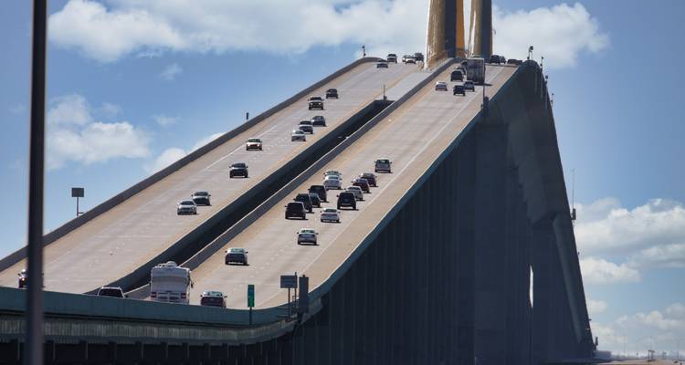 La circulation circulant de haut en bas sur la travée inclinée d'un grand pont sous un ciel bleu