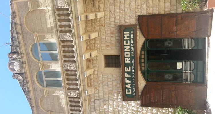 Façade en pierre du Caffè Ronchi historique avec portes en bois et signalétique vintage