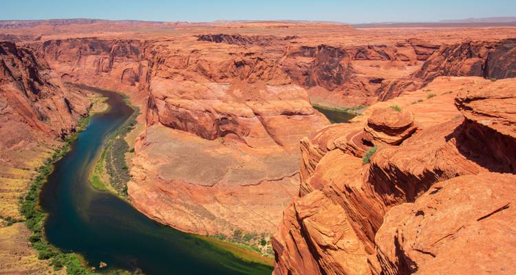 La icónica Herradura donde el río Colorado color esmeralda se curva alrededor de una península de roca roja.