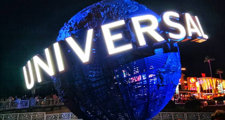 Panneau du globe illuminé Universal Studios brillant en bleu la nuit à Orlando.