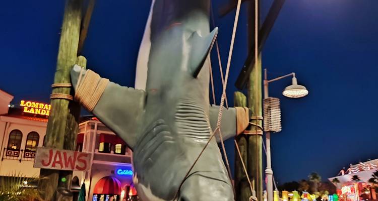Requin suspendu emblématique de l'attraction Jaws illuminé en soirée à Universal.