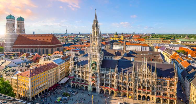 Ikonische Luftaufnahme des Marienplatzes in München mit dem Neuen Rathaus und der Frauenkirche an einem sonnigen Tag.