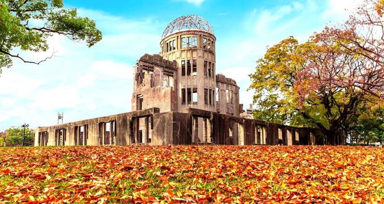 Domo Conmemorativo de la Paz de Hiroshima rodeado de hojas de otoño coloridas bajo un cielo despejado