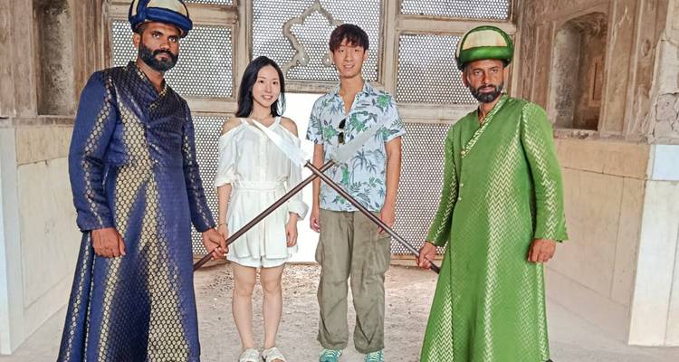 Dos turistas posan con guardias disfrazados dentro de una cámara histórica del fuerte
