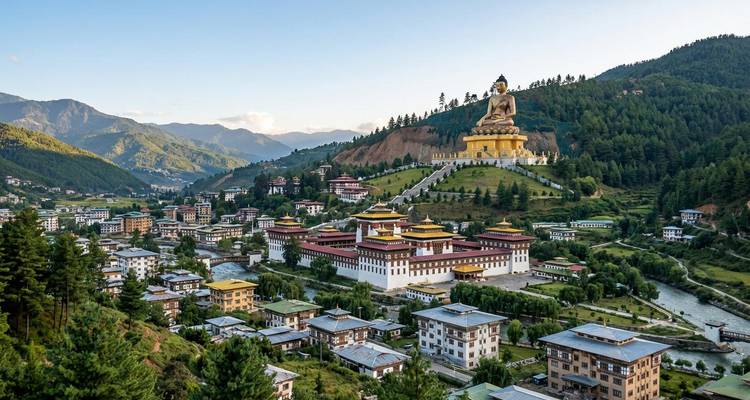 Panoramic view of Thimphu with the giant Buddha Dordenma statue overlooking the city and forested hills.