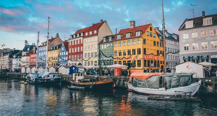 Les maisons de ville colorées du 17e siècle le long du canal Nyhavn de Copenhague avec les bateaux amarrés au crépuscule.