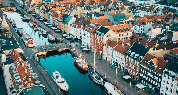 Perspective aérienne du canal de Nyhavn bordé de bâtiments aux toits rouges, de ponts et de bateaux.