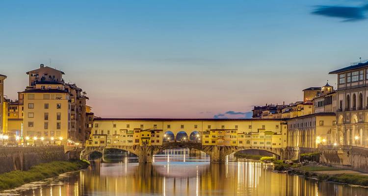 Les lumières du soir se reflétant sur l'Arno sous le Ponte Vecchio à Florence au crépuscule