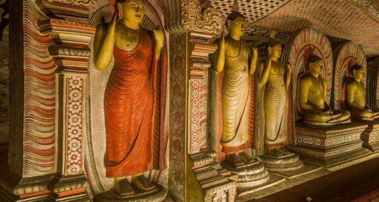 Rangée de statues de Bouddha debout colorées à l'intérieur du temple rupestre de Dambulla.
