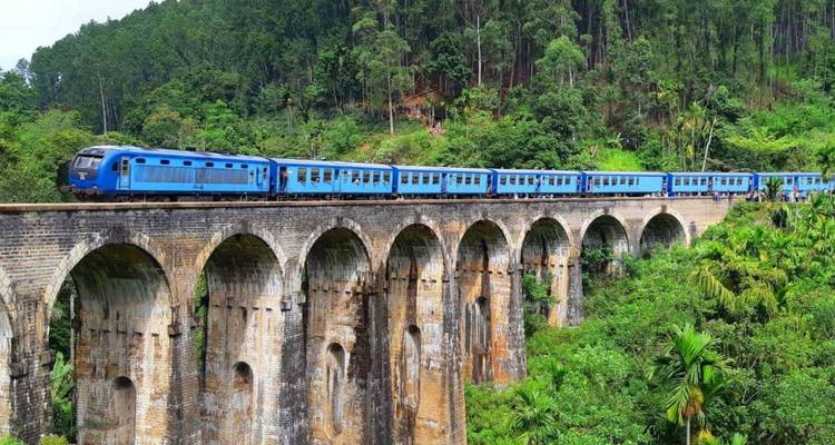 Iconische blauwe trein die de Nine-Arch Bridge kruist door de weelderige groene jungle in Sri Lanka's bergachtige gebied.