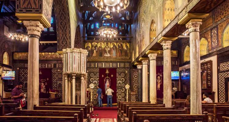 Interior ricamente decorado de la Iglesia Colgante con columnas ornamentadas, iconos y candelabros.