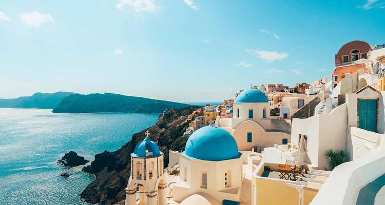 Iconische witgekalkte gebouwen met blauwe koepels liggen verspreid over de hellingen boven de Egeïsche Zee in Santorini.