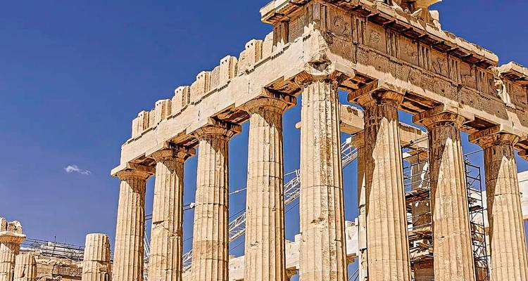 Close-upweergave van Parthenon-zuilen onder heldere blauwe lucht met zichtbare steigers