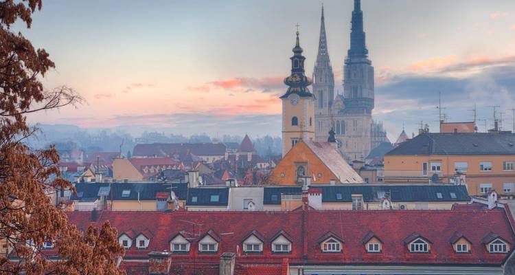 Zacht ochtendlicht over Zagrebs skyline met de twee spitsen van de kathedraal die boven de daken uitsteken
