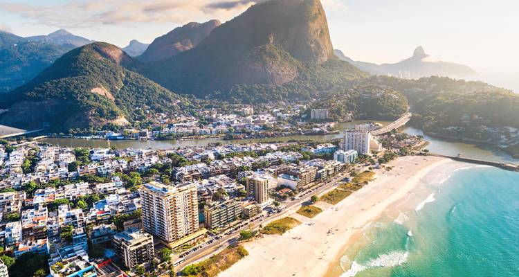 Vogelperspektive auf ein Strandviertel in Rio mit Bergen und Morgendunst.