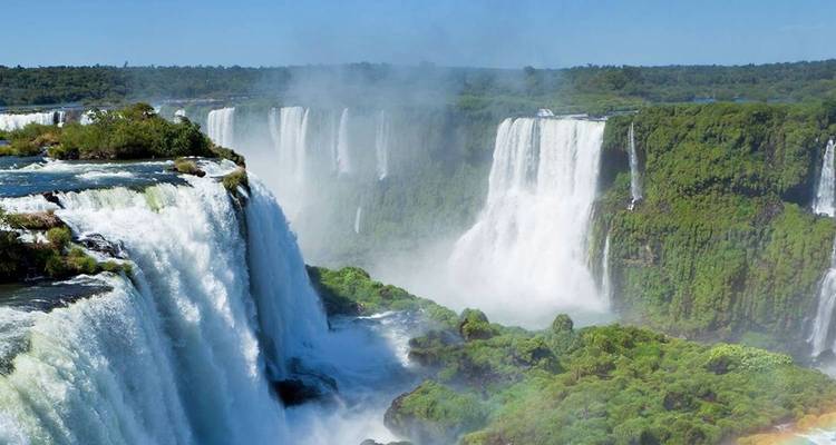 Vue panoramique spectaculaire de multiples chutes d'Iguazu se déversant dans une gorge luxuriante de forêt tropicale.