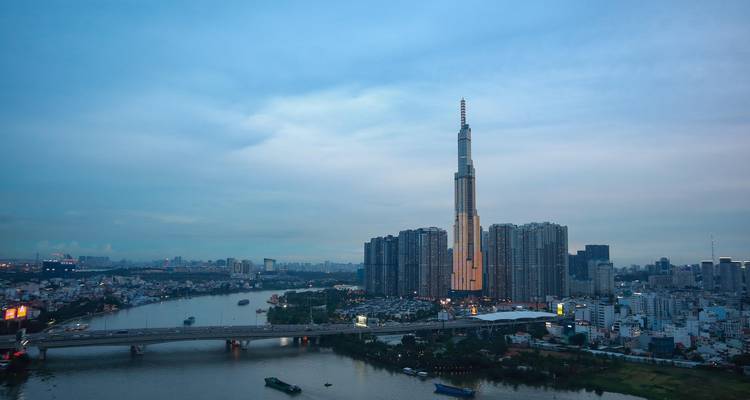 Panorama au crépuscule de la tour Landmark 81 de la ville de Ho Chi Minh-Ville et des gratte-ciel environnants à côté du fleuve et des ponts.