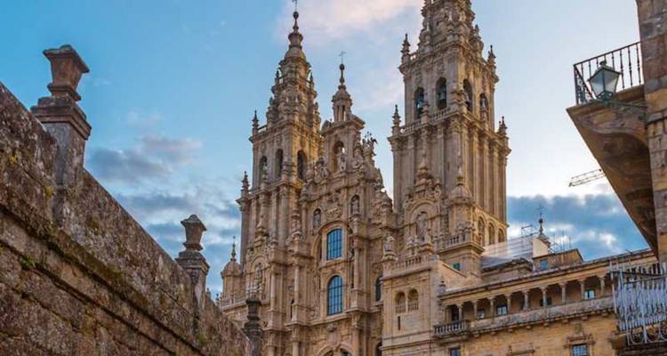Majestica fachada de doble torre de la Catedral de Santiago de Compostela contra un cielo vespertino en tonos pastel