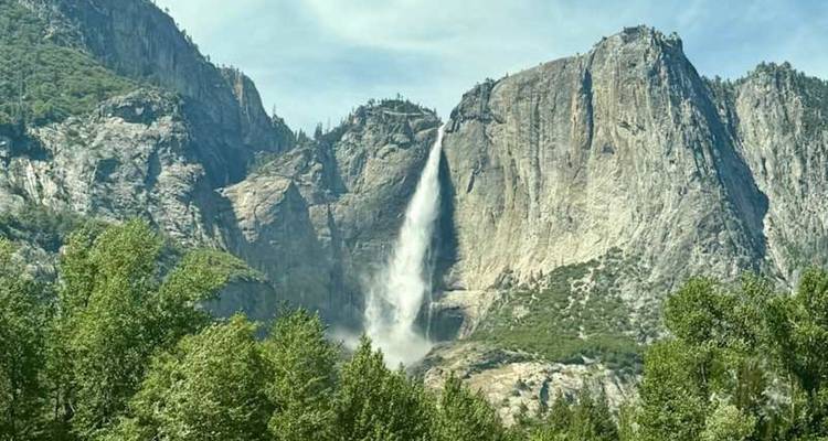 Les chutes de Yosemite se précipitent le long de parois de granit à pic dans une vallée verdoyante luxuriante par un jour dégagé.