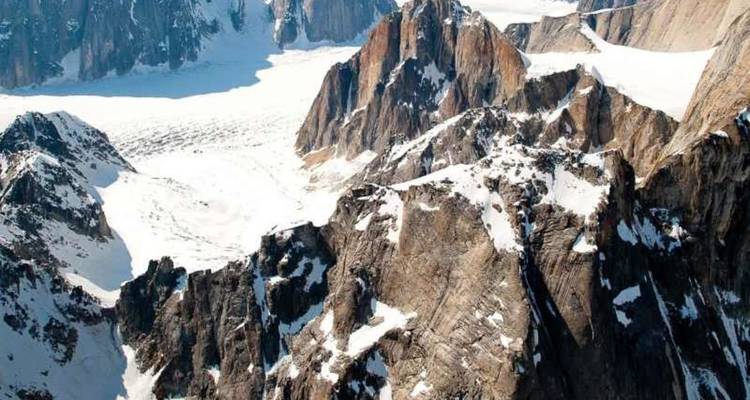 Vue aérienne des pics rocheux enneigés et des vastes champs de glaciers dans la chaîne de montagnes de l'Alaska