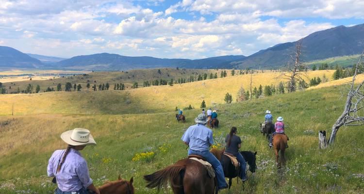 Les cavaliers traversent à cheval les collines herbeuses ondulantes sous les vastes ciels du Montana.