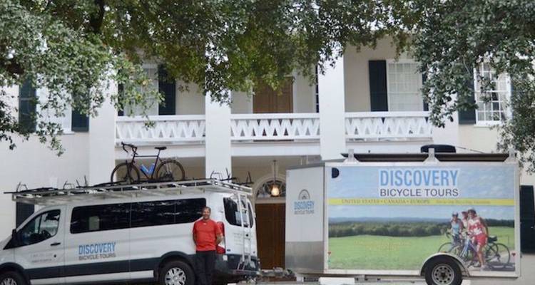 Discovery Bicycle Tours busjes met aanhanger geparkeerd voor een imposant zuidelijk landhuis