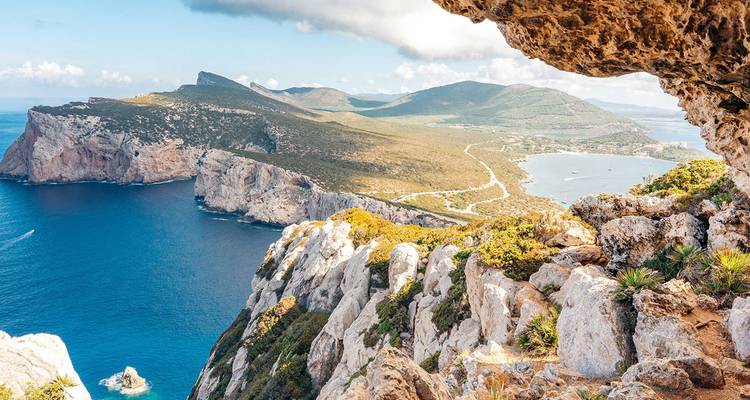 Acantilados espectaculares del Mediterráneo y un mar turquesa vistos desde la entrada de una cueva rocosa.