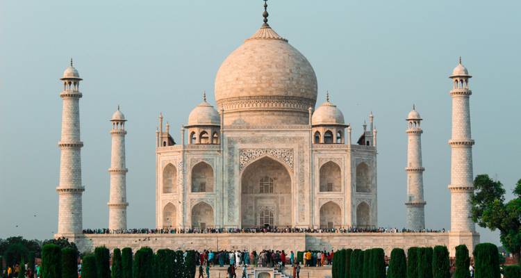Ikonische Frontalansicht des Taj Mahal mit Menschenmengen auf seiner Marmor-Terrasse an einem klaren Tag.